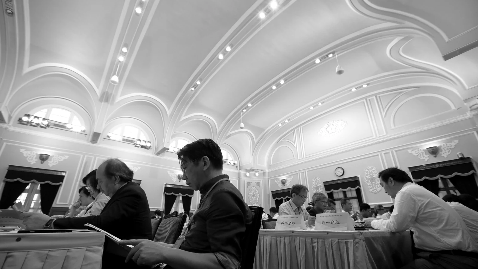 A delegate reads the session papers in the chamber