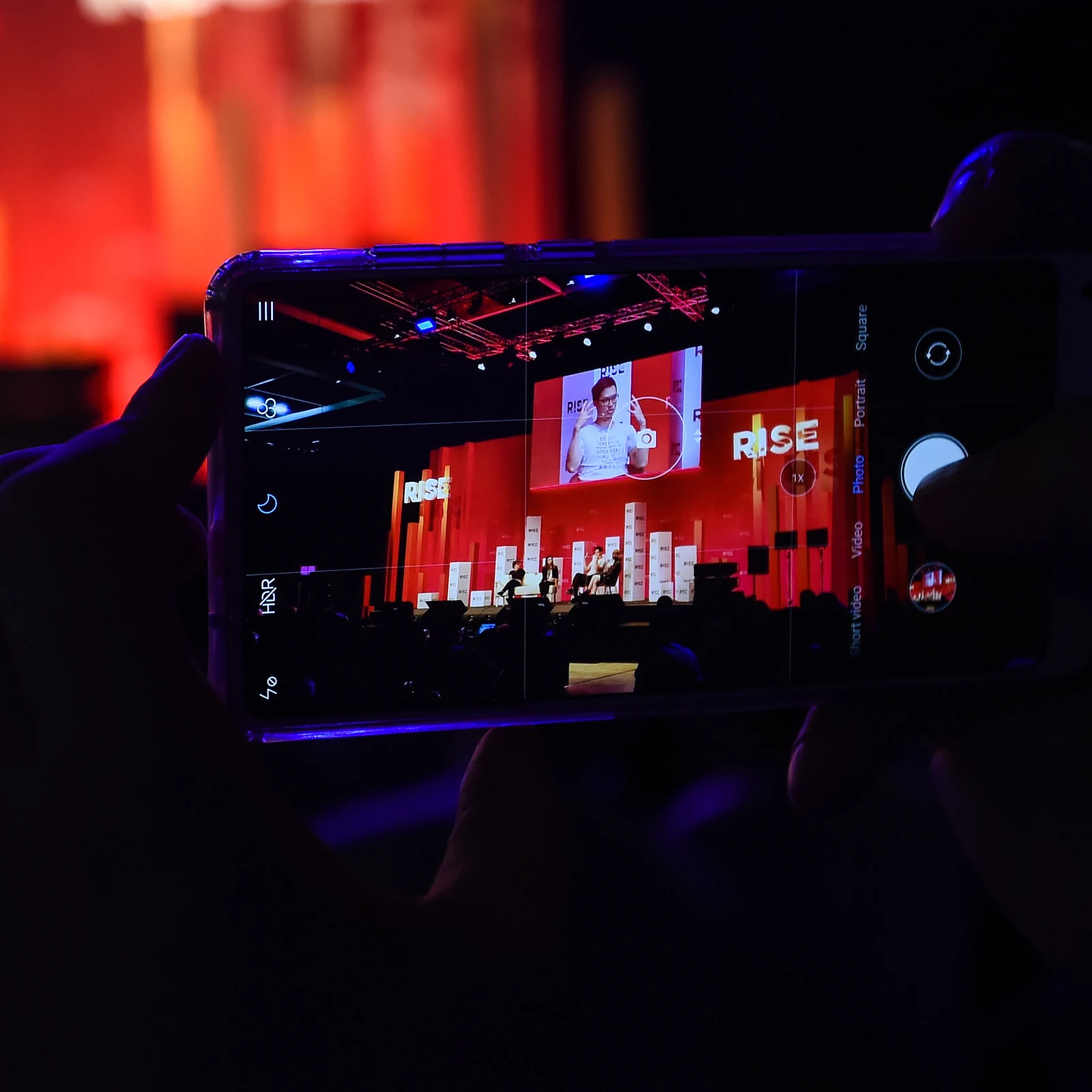 Attendee recording a Centre Stage session on a phone, RISE 2018, Hong Kong