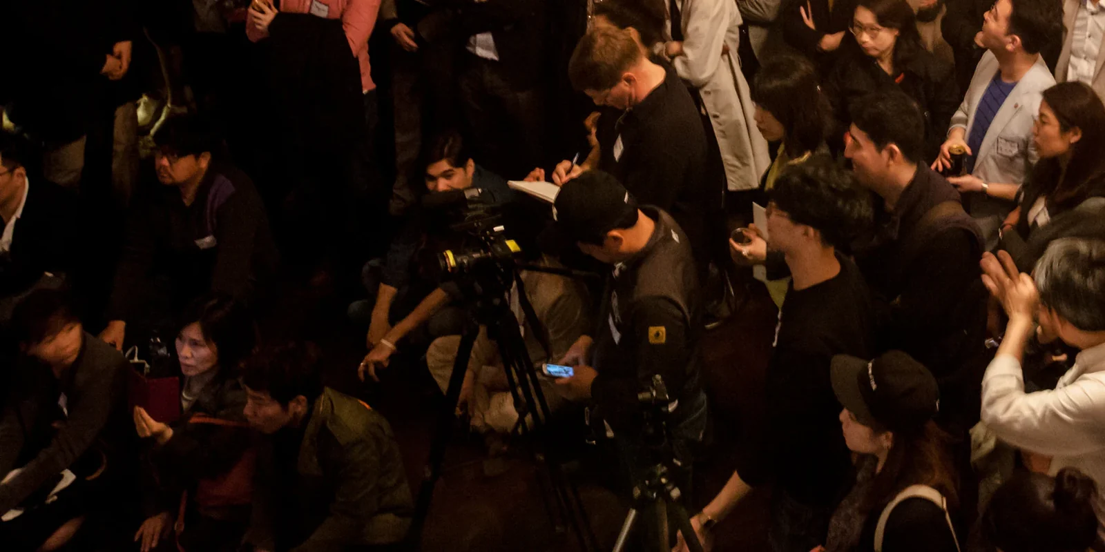 Camera crew and a note-taking attendee in the audience at TechCrunch Meetup + Pitch-off Seoul, April 2015