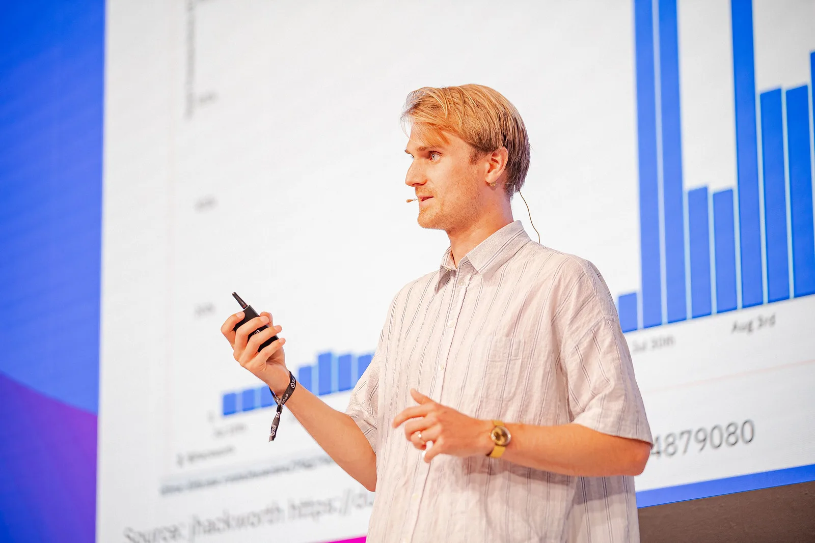 Presenter at a data wall on stage, TOKEN2049 Singapore 2023 · editorial context